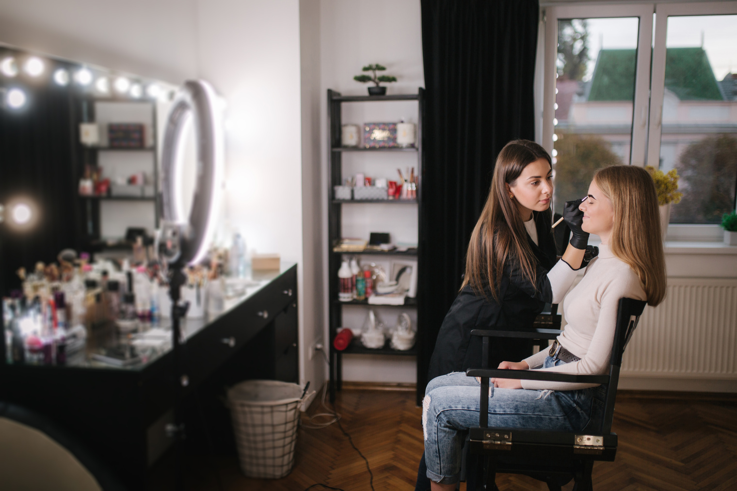 Female Makeup Artist Working on a Model's Eyebrow