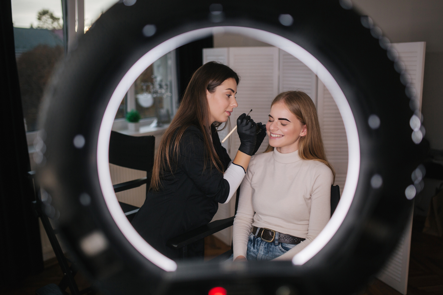 Female Makeup Artist Working on a Model's Eyebrow